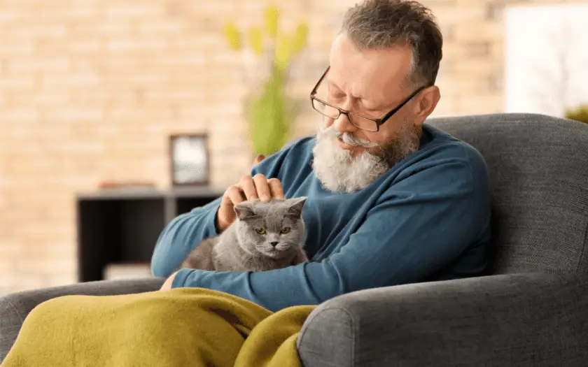 An older man sitting with his cat