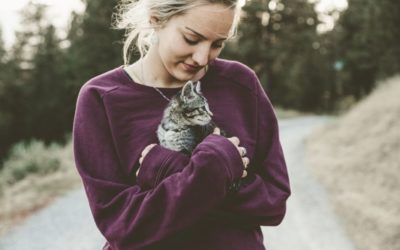Girl with purple sweater holding her cat